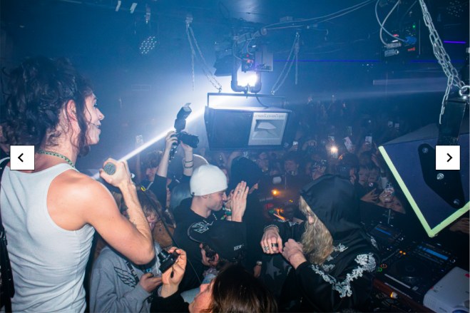 2hollis performing in a packed club, camera flash lighting the crowd